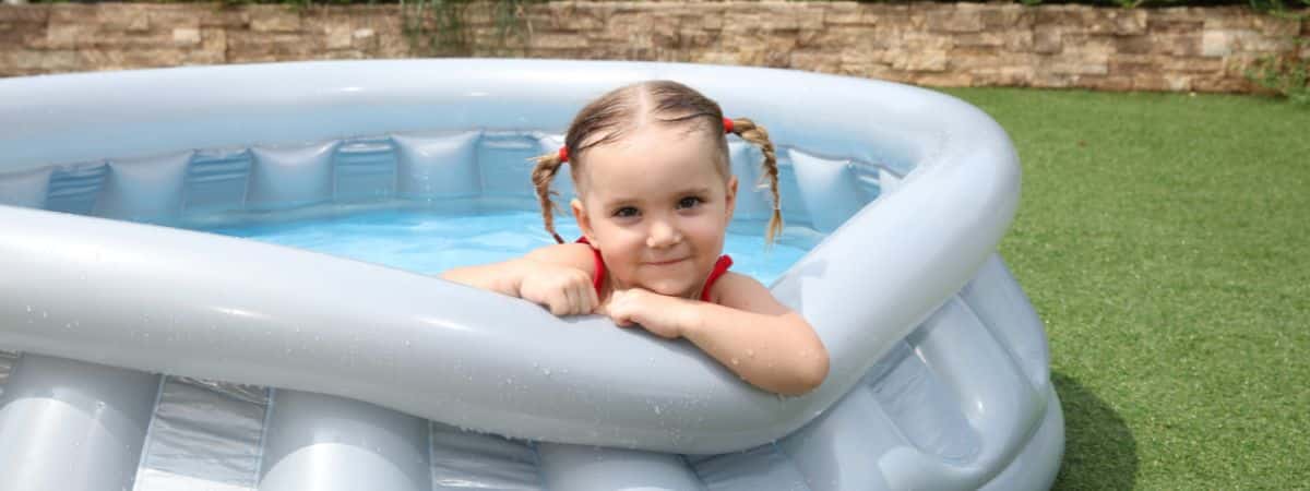 Bebê brincando em uma piscina desmontável com segurança.