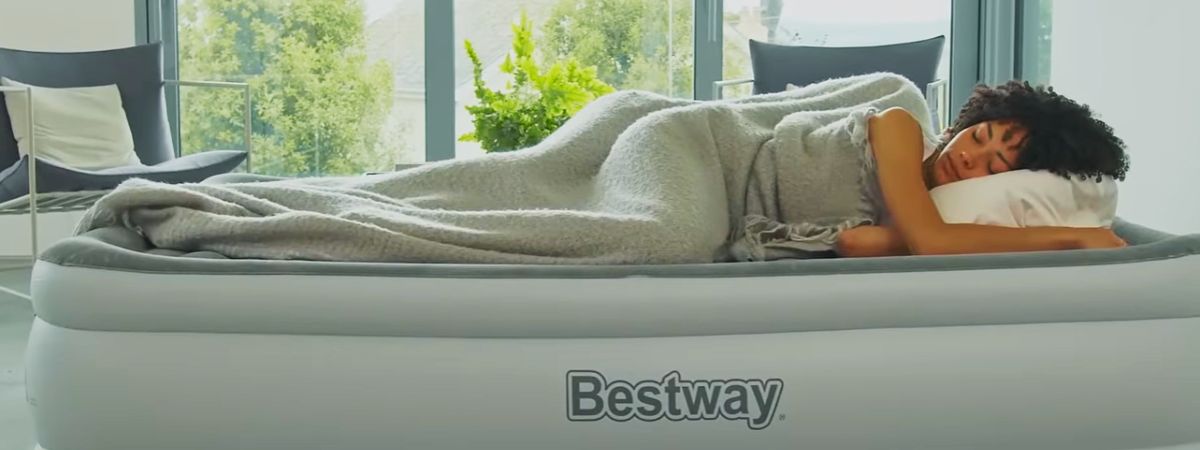 Pessoa a esvaziar e enrolar um colchão de ar numa sala